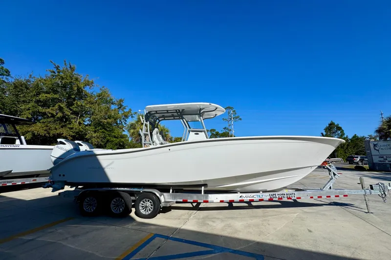 Slide: The Image of 2026 Cape Horn 32 XS boat on trailer, parked outdoors under clear blue sky. - 10