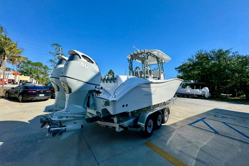 Slide: The Image of 2026 Cape Horn 32 XS boat with dual Suzuki engines on a trailer in a parking lot. - 13