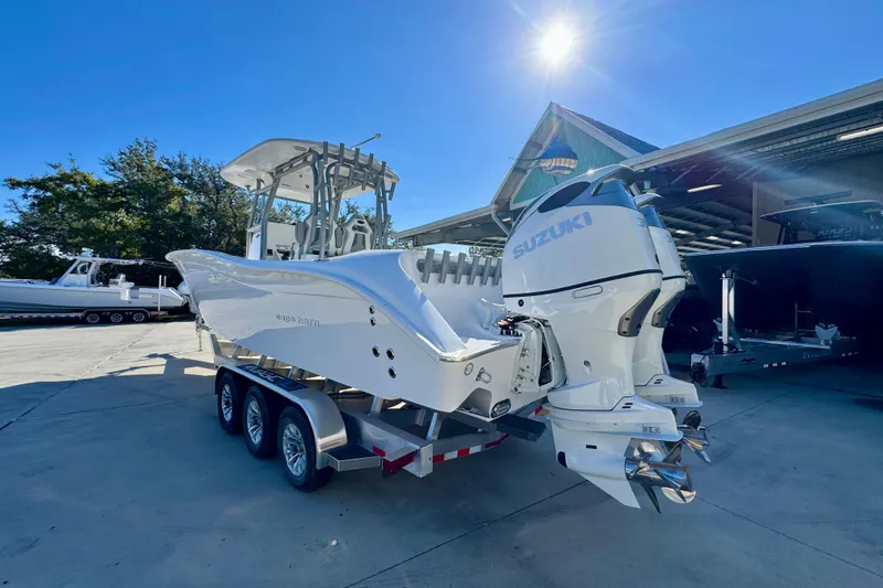 Slide: The Image of 2026 Cape Horn 32 XS boat with Suzuki engines on a trailer under bright sunlight. - 17