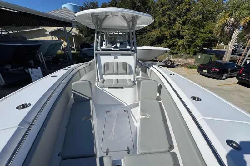Slide: The Image of 2026 Cape Horn 32 XS boat interior with seating and console, parked outdoors. - 24