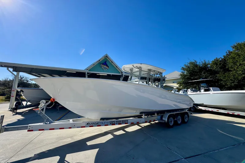 Slide: The Image of 2026 Cape Horn 32 XS boat on trailer under clear blue sky. - 3