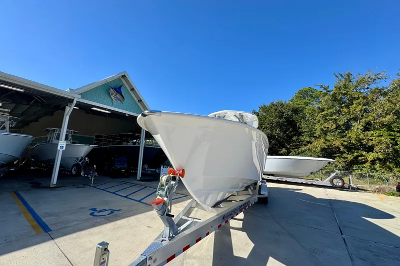 Slide: The Image of 2026 Cape Horn 32 XS boat on trailer outside a marina under clear blue sky. - 5