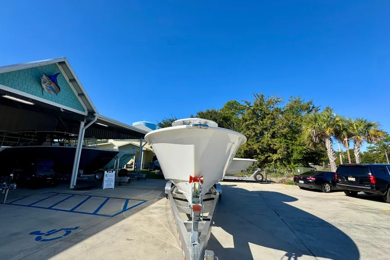 Slide: The Image of 2026 Cape Horn 32 XS boat on trailer, parked outdoors under clear blue sky. - 6