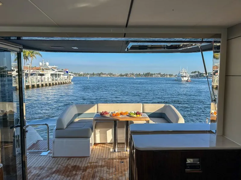 Slide: The Image of Fairline Squadron 68 (2024) yacht with a scenic waterfront view and outdoor seating area. - 36