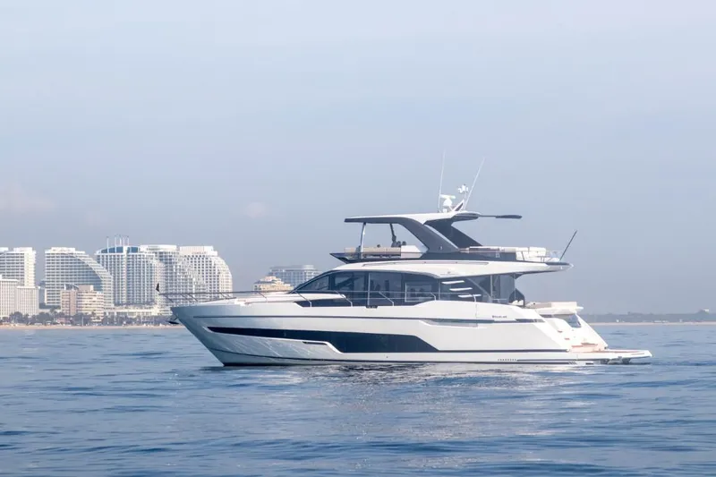 Slide: The Image of 2024 Fairline Squadron 68 yacht cruising near a coastal city skyline. - 4