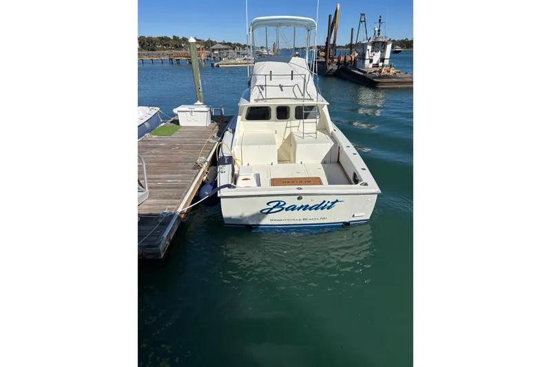 Slide: The Image of 1970 Bertram 31 Flybridge Cruiser docked, named "Bandit," in a marina setting. - 22