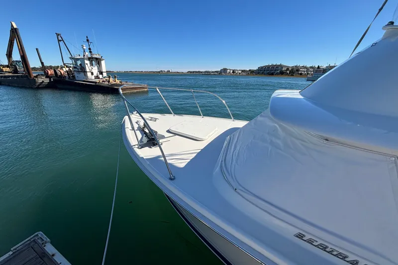 Slide: The Image of 1970 Bertram 31 Flybridge Cruiser docked in a serene marina setting. - 23