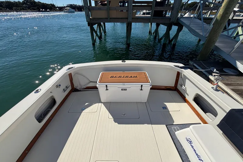 Slide: The Image of 1970 Bertram 31 Flybridge Cruiser deck with Yeti cooler, docked by serene waters. - 25