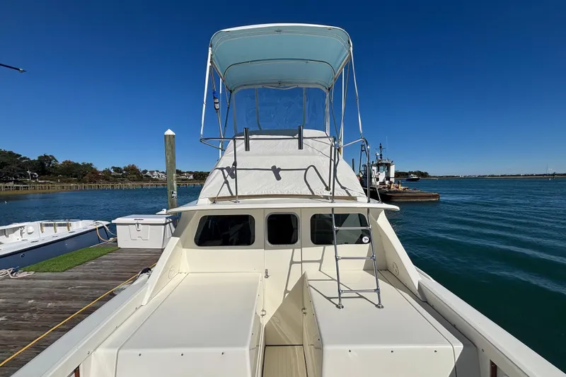 Slide: The Image of 1970 Bertram 31 Flybridge Cruiser docked by the water on a clear day. - 27