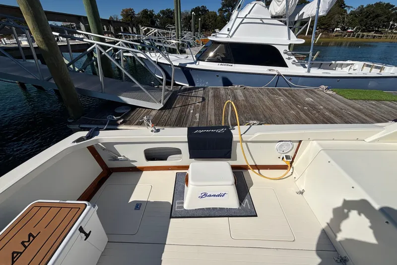 Slide: The Image of 1970 Bertram 31 Flybridge Cruiser at dock, featuring spacious deck and seating area. - 28