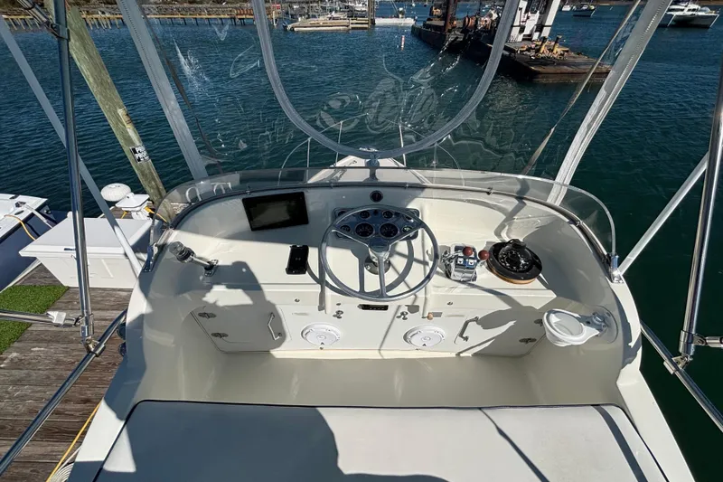 Slide: The Image of 1970 Bertram 31 Flybridge Cruiser helm with steering wheel, gauges, and navigation equipment. - 29
