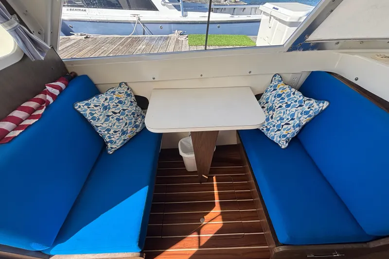 Slide: The Image of Interior of a 1970 Bertram 31 Flybridge Cruiser with blue seating and decorative pillows. - 36
