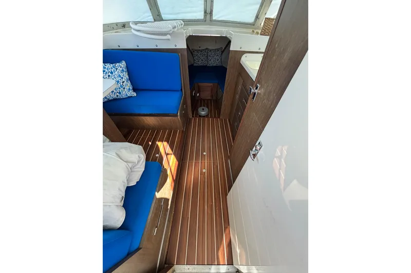 Slide: The Image of 1970 Bertram 31 Flybridge Cruiser interior with blue seating and wood flooring. - 38