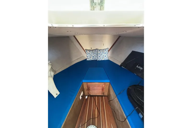 Slide: The Image of Interior of a 1970 Bertram 31 Flybridge Cruiser with blue cushions and wooden flooring. - 39