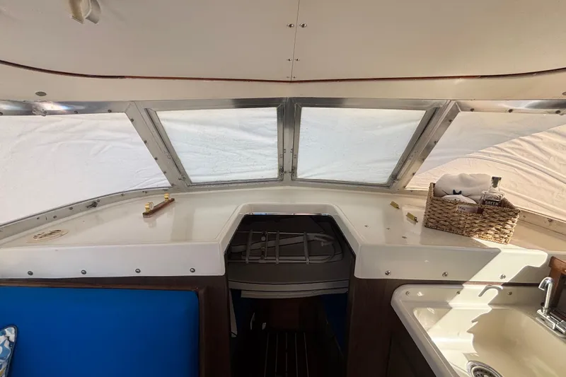 Slide: The Image of 1970 Bertram 31 Flybridge Cruiser interior with helm, windows, and wicker basket. - 41