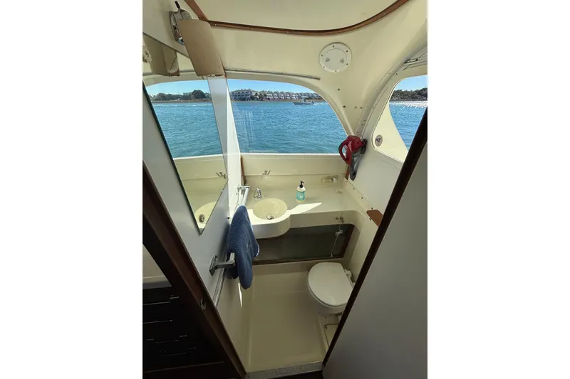Slide: The Image of 1970 Bertram 31 Flybridge Cruiser bathroom with ocean view, featuring sink and toilet. - 43