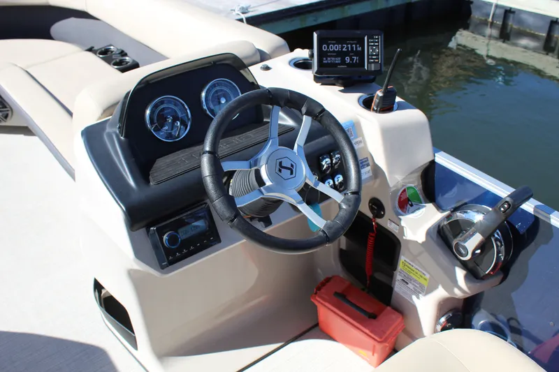Slide: The Image of 2025 Harris Cruiser 230 boat dashboard with steering wheel and control panel. - 14