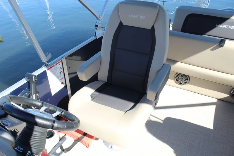 Slide: The Image of 2025 Harris Cruiser 230 boat interior with captain's chair and steering wheel. - 18
