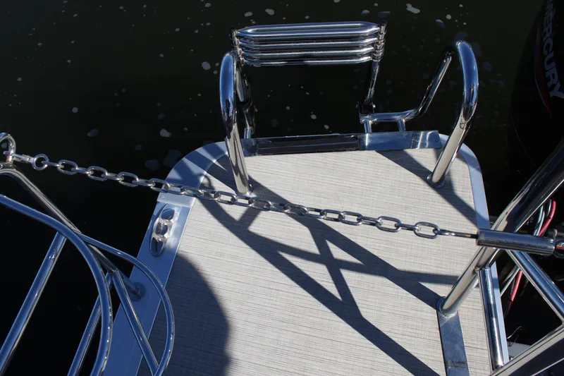 Slide: The Image of Rear deck of 2025 Harris Cruiser 230 boat with metal ladder and chain railing. - 22