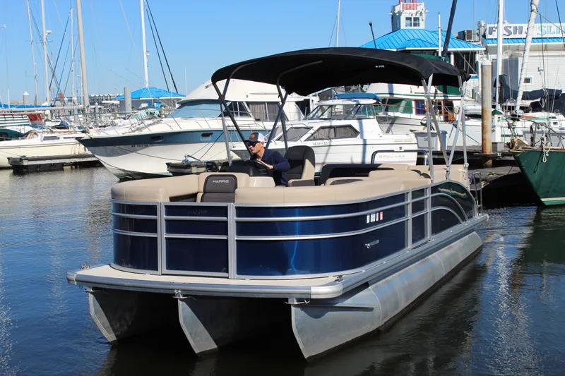 Slide: The Image of 2025 Harris Cruiser 230 pontoon boat docked at a marina, featuring a sleek design. - 5