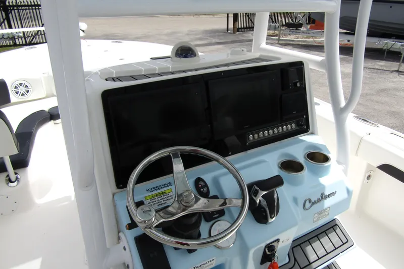 Slide: The Image of 2021 Tidewater 2700 Carolina Bay boat console with steering wheel and controls. - 21