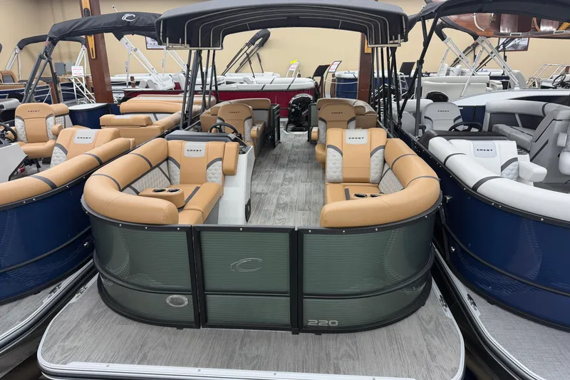 The Image of 2025 Crest Classic 220 pontoon boat with tan seating and sleek design in showroom. - 0