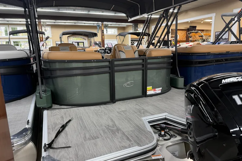 Slide: The Image of 2025 Crest Classic 220 pontoon boat interior with tan seating and Mercury engine. - 2