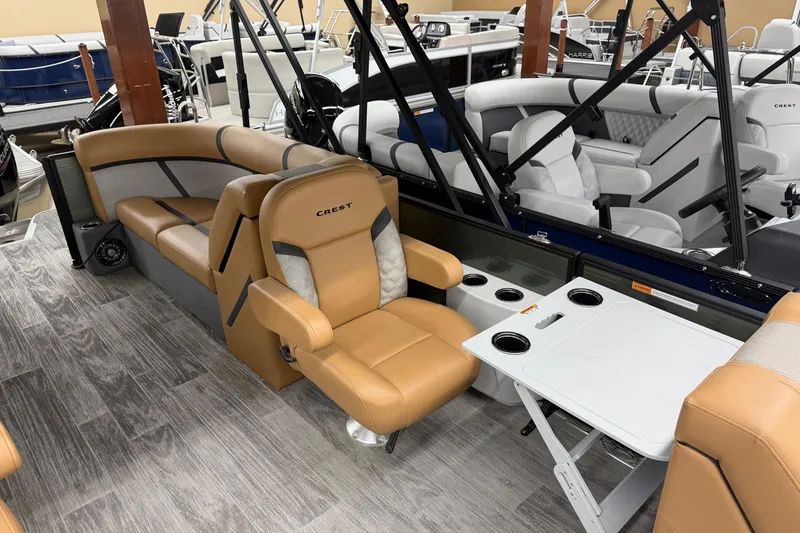 Slide: The Image of 2025 Crest Classic 220 boat interior with tan seating and foldable table. - 5