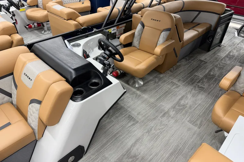 Slide: The Image of 2025 Crest Classic 220 boat interior with tan seating and modern helm design. - 6