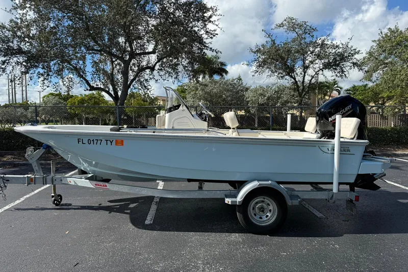 Slide: The Image of 2025 Boston Whaler 170 Montauk boat on trailer in parking lot, sunny day. - 0