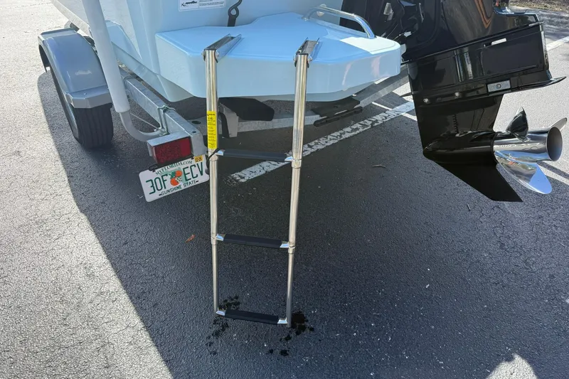 Slide: The Image of 2025 Boston Whaler 170 Montauk boat with ladder and trailer in parking lot. - 12