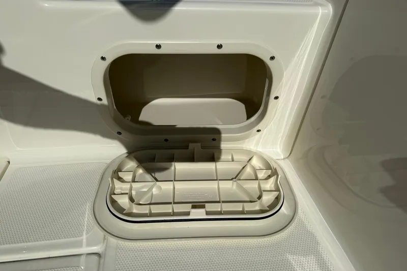 Slide: The Image of 2025 Boston Whaler 170 Montauk storage compartment detail in bright sunlight. - 28
