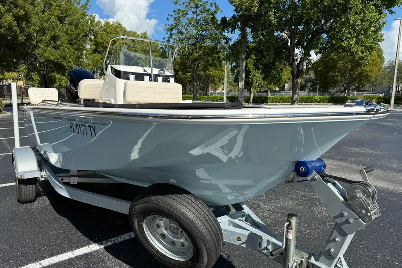 Slide: The Image of 2025 Boston Whaler 170 Montauk boat on trailer in sunny parking lot. - 3