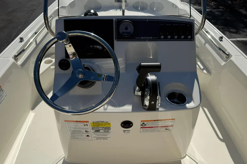 Slide: The Image of 2025 Boston Whaler 170 Montauk boat console with steering wheel and controls. - 36