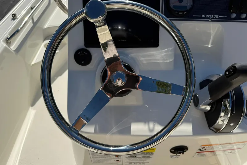 Slide: The Image of 2025 Boston Whaler 170 Montauk steering wheel and controls, showcasing modern design. - 37