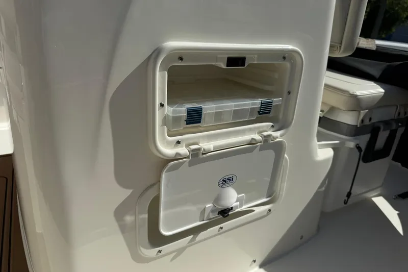 Slide: The Image of 2025 Boston Whaler 170 Montauk storage compartment with open hatch and tackle box. - 48