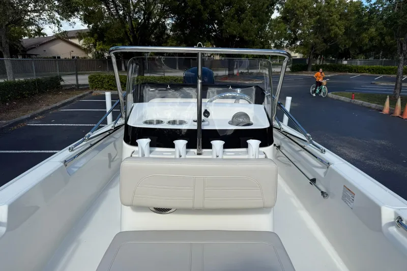 Slide: The Image of 2025 Boston Whaler 170 Montauk boat interior with console and seating in a parking lot. - 50