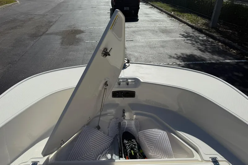 Slide: The Image of 2025 Boston Whaler 170 Montauk boat storage compartment open in parking lot. - 55