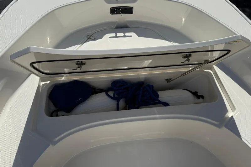 Slide: The Image of 2025 Boston Whaler 170 Montauk storage compartment with rope and fender. - 56