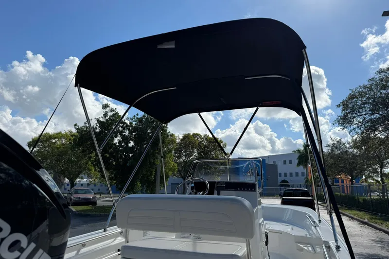 Slide: The Image of 2025 Boston Whaler 170 Montauk boat with canopy under a sunny sky. - 6