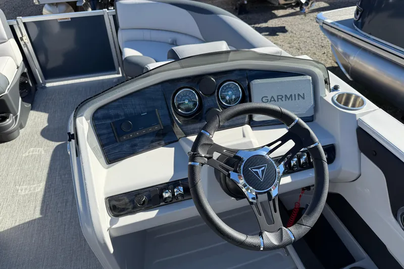 Slide: The Image of 2026 Tahoe Pontoon LTZ Quad Lounger Shift dashboard with Garmin navigation and steering wheel. - 4