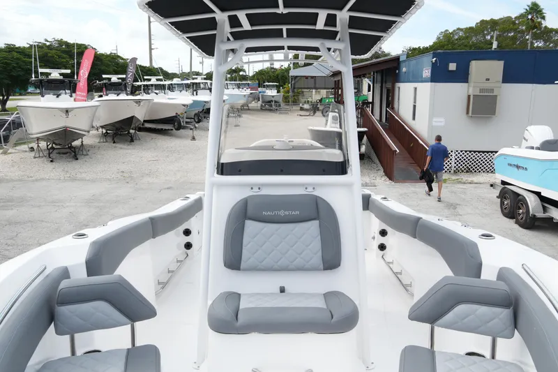 Slide: The Image of 2025 NauticStar 222 Offshore boat with gray seating, displayed at a marina. - 13