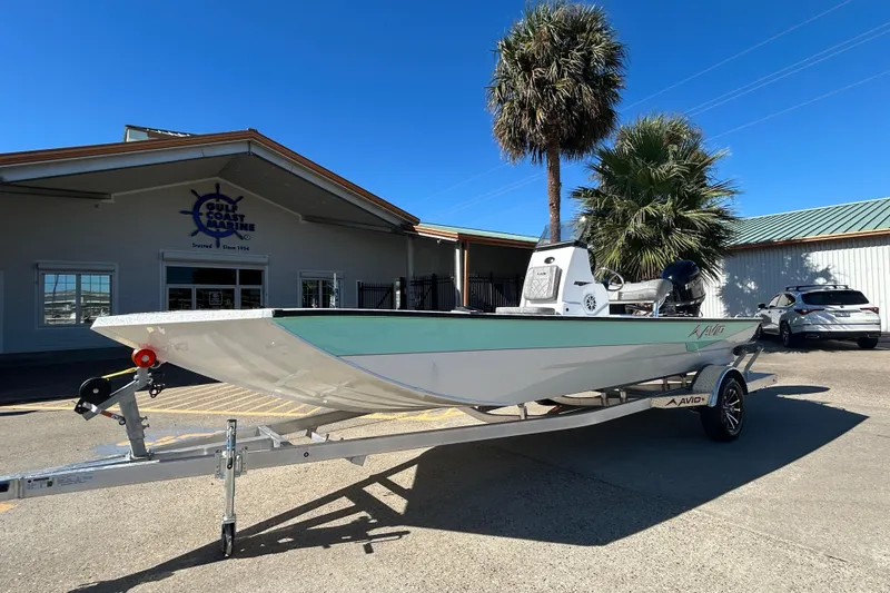 Slide: The Image of 2026 Avid 21 Recon ST boat on trailer outside Gulf Coast Marine building. - 1