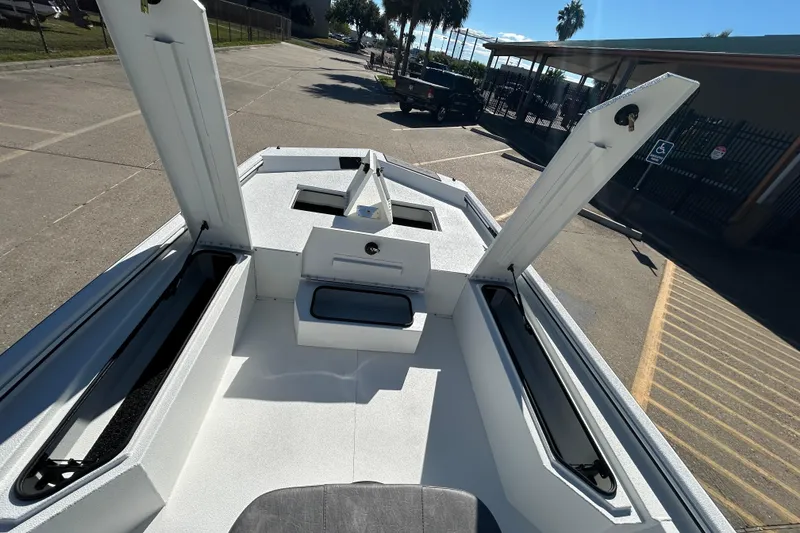 Slide: The Image of 2026 Avid 21 Recon ST boat with open storage compartments in a parking lot. - 16