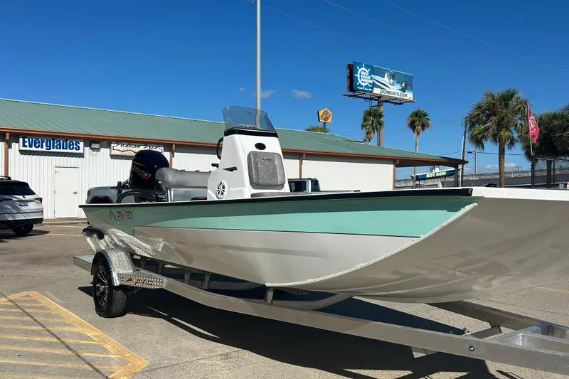 Slide: The Image of Avid 21 Recon ST 2026 boat on trailer outside dealership under clear blue sky. - 3