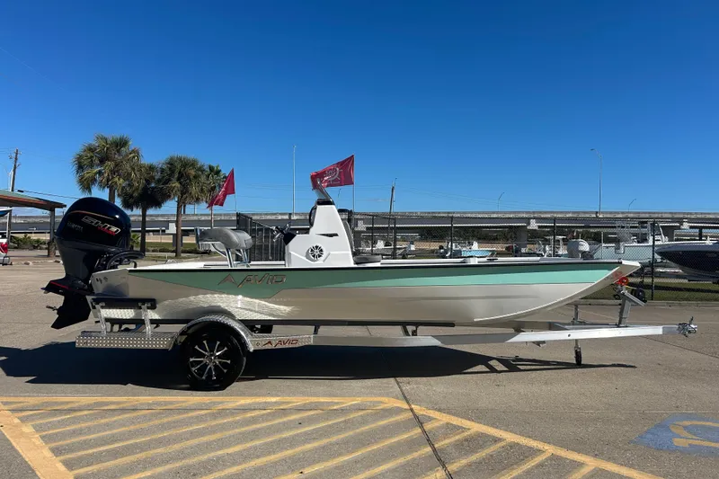 Slide: The Image of Avid 21 Recon ST 2026 boat on trailer, parked outdoors under clear blue sky. - 4