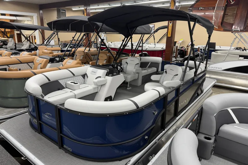 The Image of 2025 Crest Classic 200 pontoon boat with sleek design and spacious seating in showroom. - 1