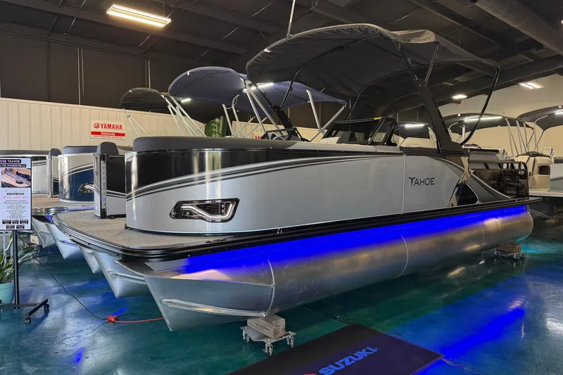 The Image of 2026 Tahoe Pontoon LTZ Elite Windshield boat displayed indoors with blue underglow lighting. - 0