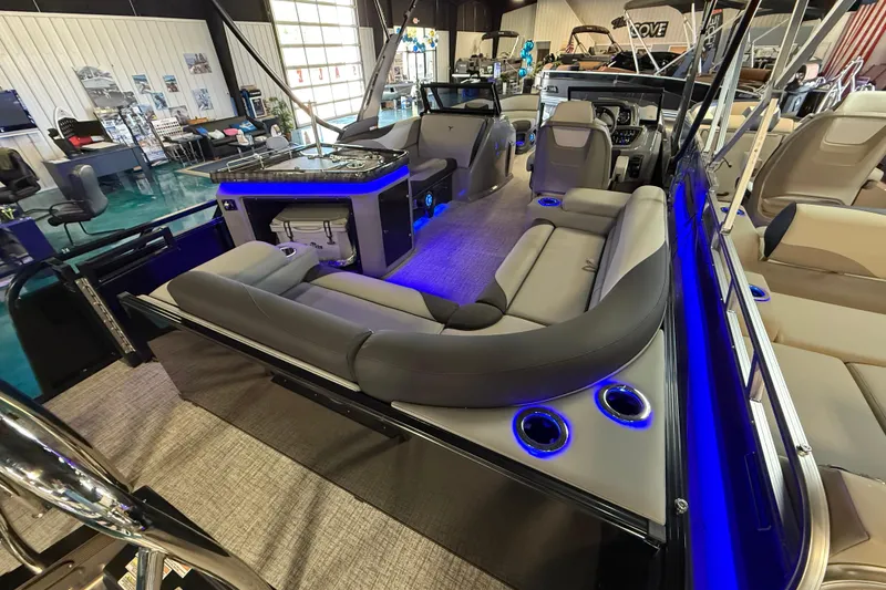 Slide: The Image of 2026 Tahoe Pontoon LTZ Elite Windshield with luxurious seating and ambient blue lighting. - 2