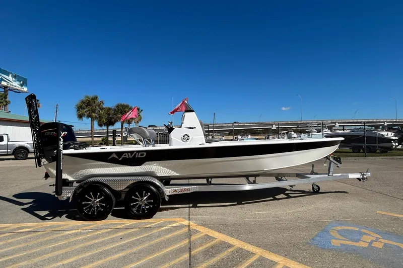 Slide: The Image of 2026 Avid 21 FST boat on trailer, parked outdoors under clear blue sky. - 4
